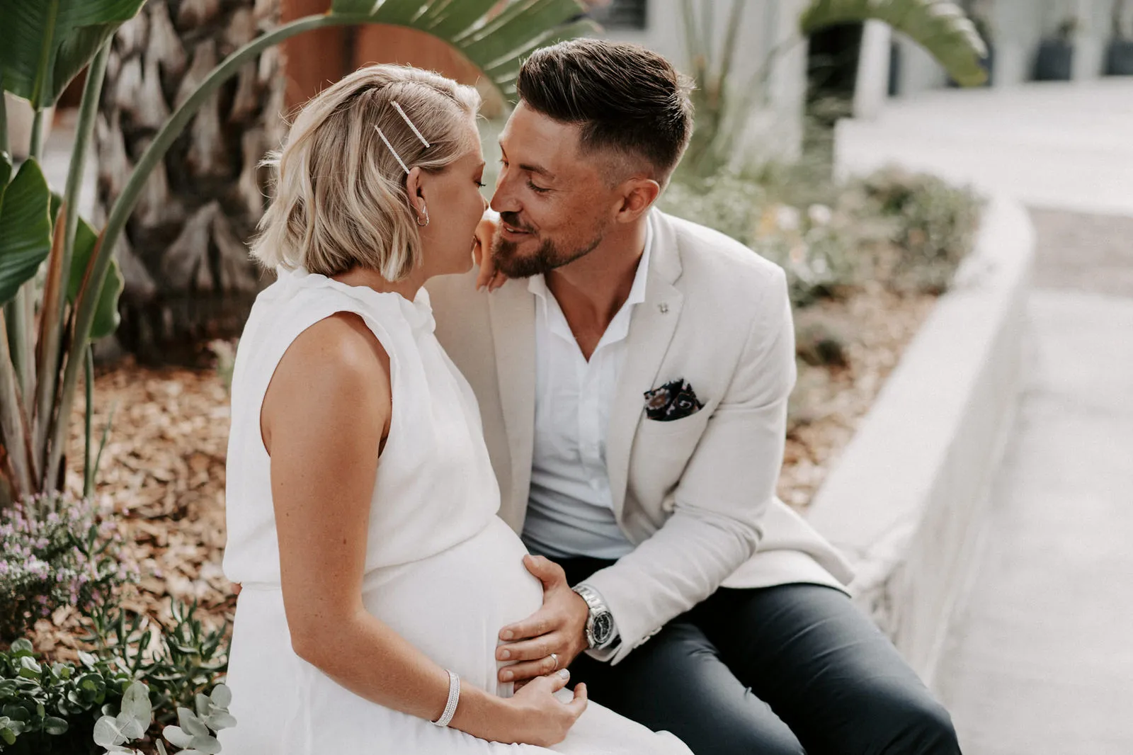 Shannon and Jacksen sharing a kiss among the garden palms