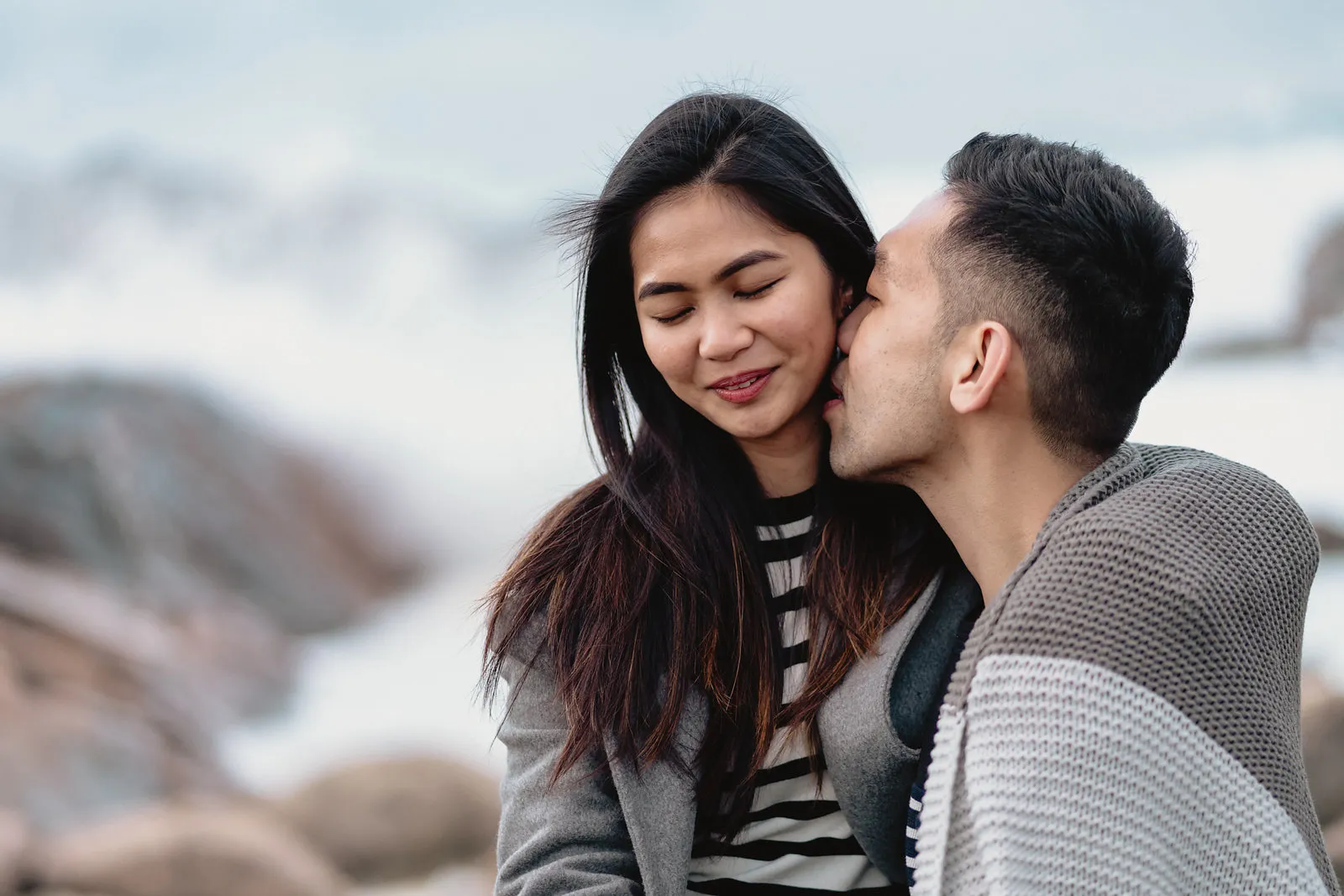 Vryan kissing Zaneta’s cheek, a blanket around his shoulders